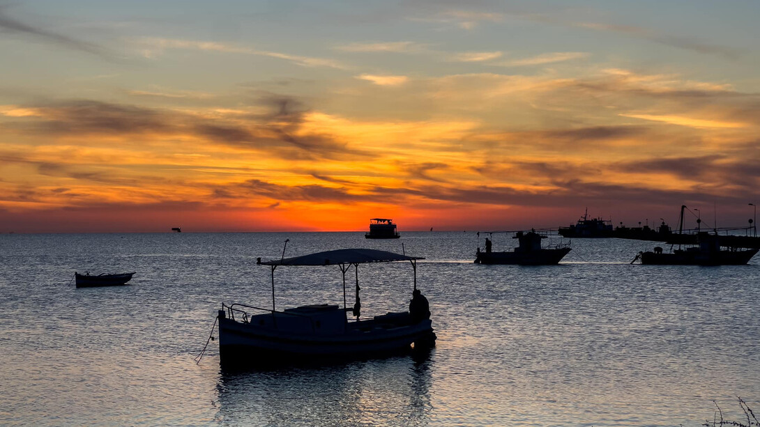As the sun sets over the island of Kerkannah, Tunisia, the sky becomes a canvas of intense reds and deep oranges, a perfect backdrop for an artist’s reflection, image taken by Pierre Gassin