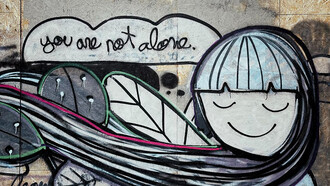 Wall art in Lisbon, Portugal depicting a man hugging a woman—a powerful expression of love and self-expression