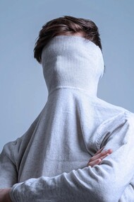 Hombre esconde el rostro en el cuello de su jersey. Identidad es el concepto que cada persona tiene de su individualidad y de su pertenencia a grupos