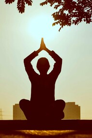 A silhouette of a person practicing yoga at sunrise, surrounded by nature’s tranquility