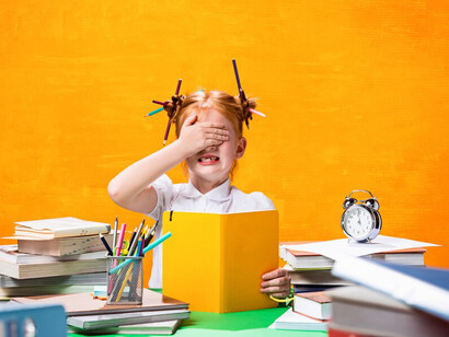 A stressed redhead teen girl at home surrounded by books, illustrating the impact of academic pressure on children's mental health
