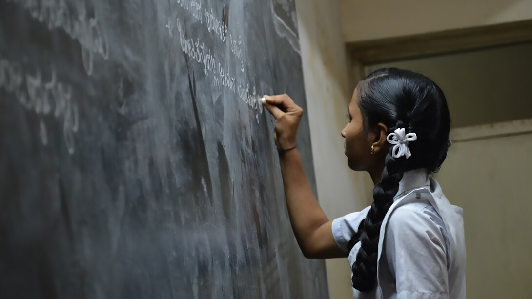 A student writing on the blackboard in a classroom, Bengaluru, India