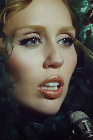 Miley Cyrus in the Something Beautiful video, portraying a powerful moment of self-reflection and artistic rebirth