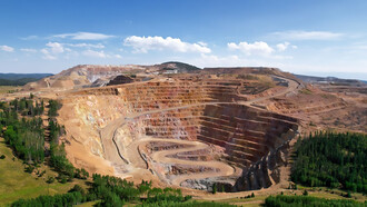 A vast open pit mining operation carved into the heart of a forest, symbolizing the destructive impact of green colonialism and the exploitation of resources in the Global South