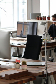 A man sits in front of a computer, surrounded by the clean lines and simplicity of a minimalist office space in Berlin, Germany
