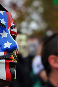 Close-up photo of person wearing Guy Fawkes mask, symbolizing anonymity and protest