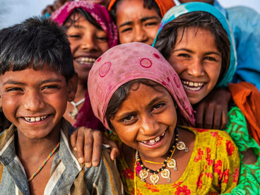 Children from different ethnic communities in a desert village, India, smiling together, representing the genetic and cultural diversity highlighted in the Indian Genome Project