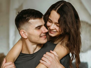 Una giovane coppia che si abbraccia e si guarda con affetto