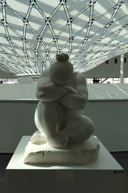 Summer: an unclothed woman crouched down, her head deeply buried in her folded arms in a closed, inward posture