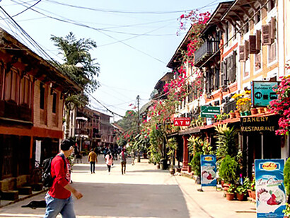 A man strolling past concrete structures in the daytime in Bandipur, Nepal