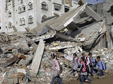 Children walk through debris following an Israeli attack in Gaza in 2012, Palestine