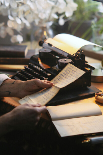 A man typing at a typewriter on his desk