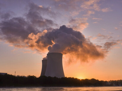 The glow of the setting sun against the industrial backdrop of the coal power station reflects the pressing need for inclusive and well-governed strategies in the shift to sustainable energy