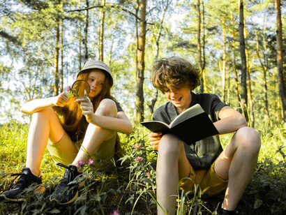 Children exploring knowledge in a forest, conveying the power of curiosity to reduce fear of the unknown
