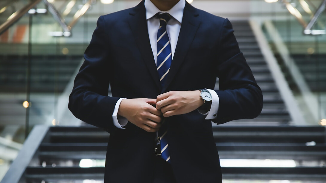 A person in a suit stands near the stairs, Auckland, New Zealand
