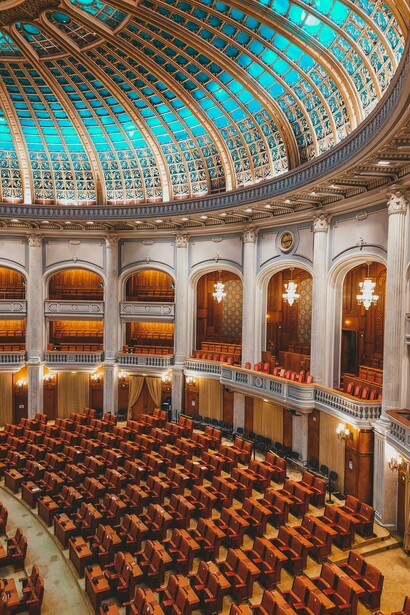 Inside a grand parliamentary building with a large dome
