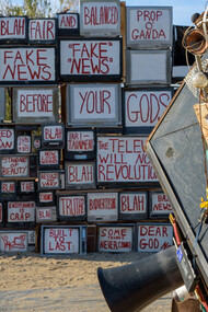 A wall of truth, TVs with words of fake news and propaganda messages in front of an old news camera