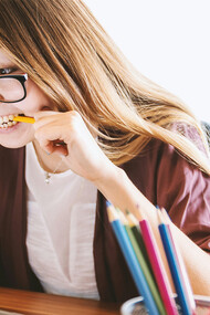 Mulher estressada mordendo lápis. Existem três tipos de estresse que são estresse agudo, estresse agudo episódico e crónico