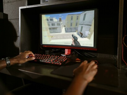 A gamer intensely focused while playing Counter-Strike on a computer
