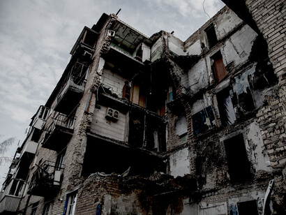 Destroyed residential building under a gray sky during the Russia–Ukraine war, Ukraine