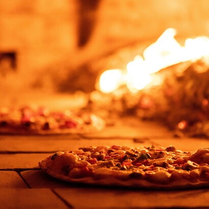 La pizza è memoria e futuro: custodisce la sapienza dei forni di pietra e si rinnova ogni giorno nelle mani di chi la impasta con passione