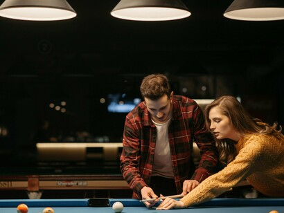 A friendly pool game among peers, conveying the overlooked importance of play in mental well-being