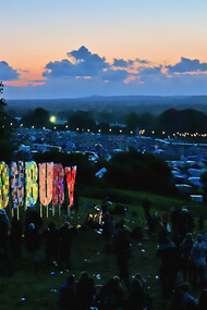 The Glastonbury Festival 2011 captured at night, glowing with lights, music, and the energy of thousands of festivalgoers