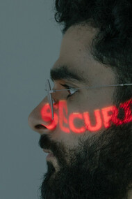 Jovem programador tem a palavra segurança projetada em seu rosto