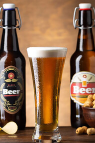 A snack of chips and peanuts arranged in front of beer bottles, perfect for a relaxed evening