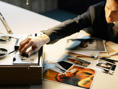 A suited individual reviewing photographs as part of a federal investigation