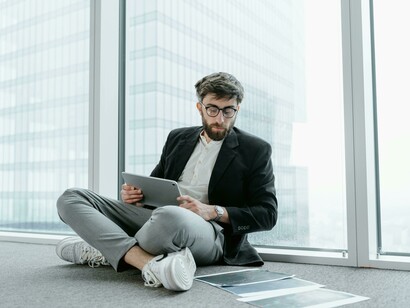 A young professional sits in a high-rise office, disconnected from traditional ambition
