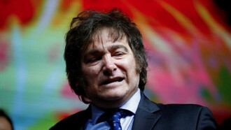 Close up of President Javier Milei on stage, with his iconic ''wig'' of messy hair