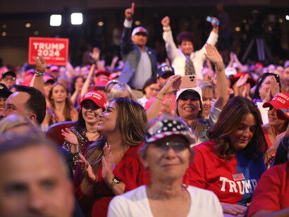 Trump supporters with signs, clothes, and accessories, showing their approval