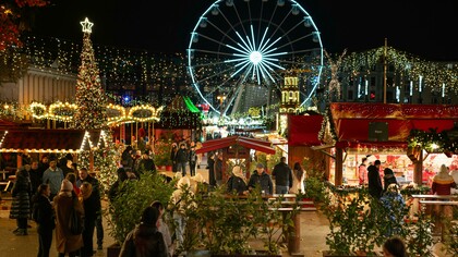 Christmas market beneath an illuminated Ferris wheel in Poznań, Greater Poland Voivodeship, Poland