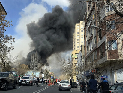 Missiles streak across the sky as smoke hangs over Tehran on the fourth day of war, Iran