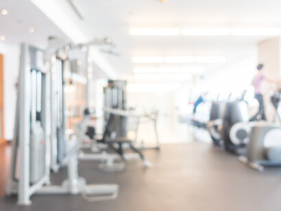 Sala pesi in una palestra con diverse macchine e attrezzature, mostrata con un effetto sfocato