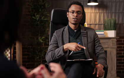 A male psychotherapist conducting a psychoanalysis session with a couple in his office, offering relationship guidance