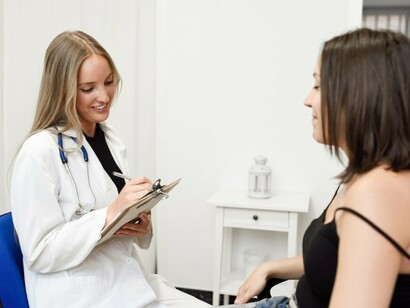 A female doctor explains a diagnosis to her young female patient with care and clarity