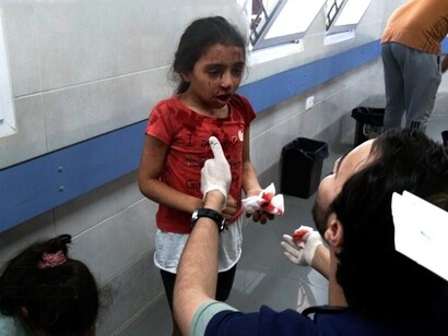 Nella foto una bambina palestinese riceve le prime cure dopo essere stata coinvolta, foto di Saleh Najm and Anas Sharif