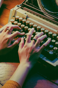 Roteirista e diretora escreve uma narrativa em máquina de escrever 