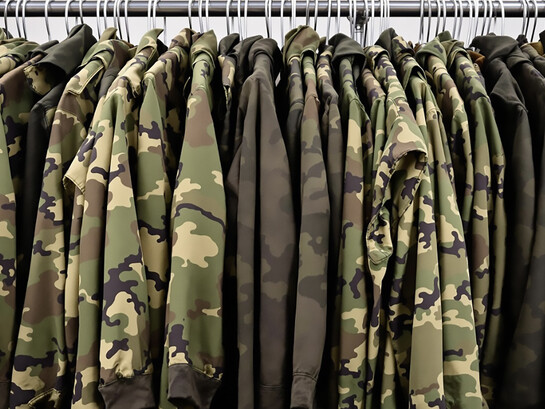 Military uniforms hanging on clothing rack