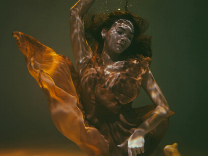 Woman submerged underwater, floating in a dress