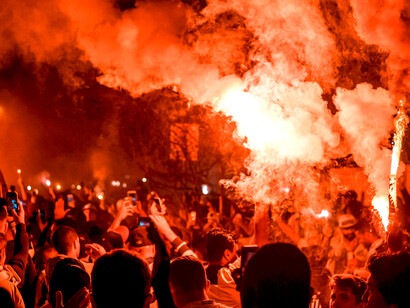 Anonymous people standing in the street amid smoke during nighttime protests