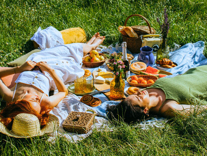 A group of women lounging on the grass during a picnic, enjoying unhurried time together
