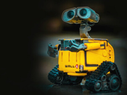 A yellow and gray robot toy stands as a quiet emblem of artificial intelligence and emotion — where technology brushes against the edges of grief