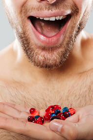 Cropped image of a happy man taking multivitamin supplements