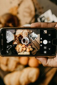 Homem tira foto para post a respeito de comida de restaurante. Um trabalho que até pouco tempo atrás era feito somente por críticos gastronômicos, especialistas que trabalham para veículos de comunicação e que faziam questão de visitar os restaurantes anonimamente, com grande compromisso com a imparcialidade, hoje já parece não ter mais tanta relevância