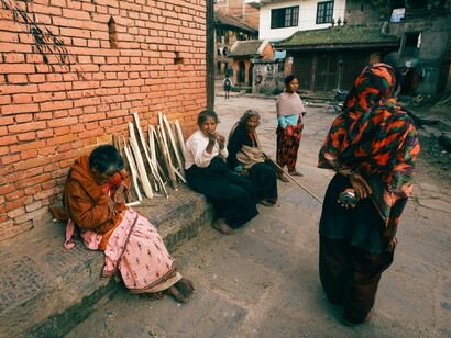 A group of homeless women gathered on a city street, symbolising the collective vulnerability created by the global housing crisis