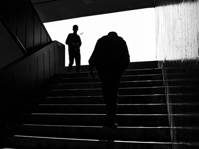 Lonely figures captured in black and white on the steps of a subway station