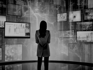 A human silhouette bathed in shifting light from countless digital displays, caught between reality and code